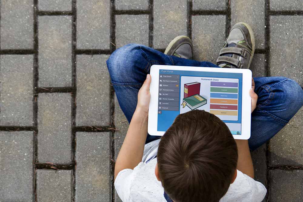 student portal on tablet used by boy on path